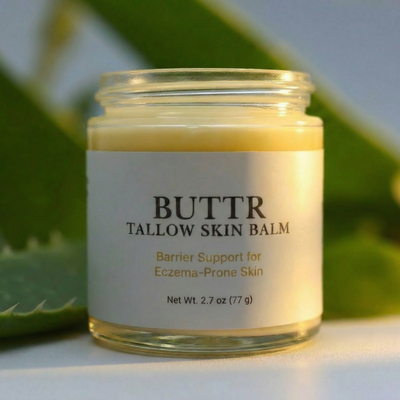 Jar of BUTTR Tallow Skin Balm with a green leafy background
